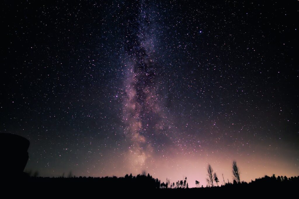 A stunning night view of the Milky Way galaxy over a serene landscape, perfect for nature wallpapers.